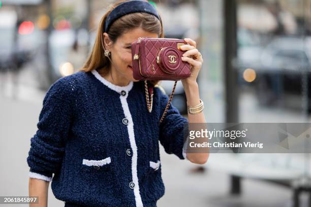 Monica de La Villardiere wears navy cardigan, hair loop, burgundy bag outside Chanel during the Womenswear Fall/Winter 2024/2025 as part of Paris...