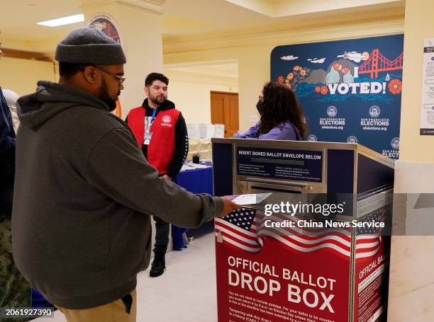 Voter drops his ballot into a ballot box during the presidential primary at a polling station inside San Francisco City Hall on Super Tuesday on...