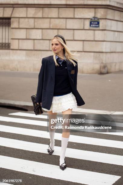 Leonie Hanne wears white mini skirt, blue shirt, navy bue vest and a hand bag outside Miu Miu during the Womenswear Fall/Winter 2024/2025 as part of...