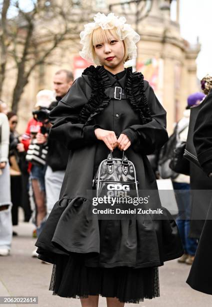 Coto is seen wearing a black Comme Des Garcons dress and CDG bag with white sneakers and white sheer headpiece outside the Miu Miu show during the...