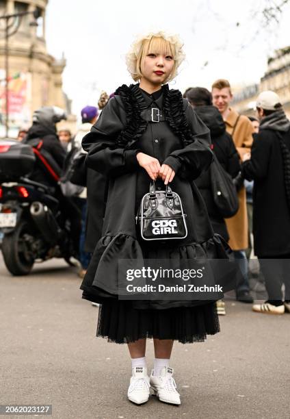 Coto is seen wearing a black Comme Des Garcons dress and CDG bag with white sneakers and white sheer headpiece outside the Miu Miu show during the...