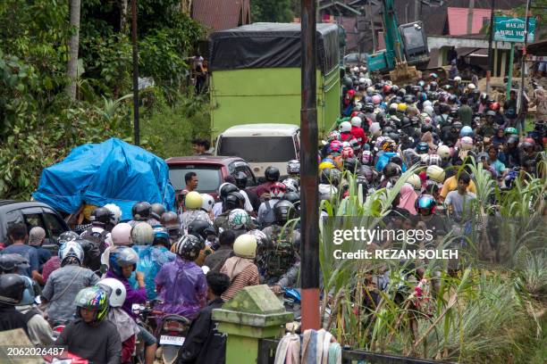 Traffic jam is seen as motorists drive through a muddy road following flash flooding in Pesisir Selatan Regency, West Sumatra on March 9 after days...