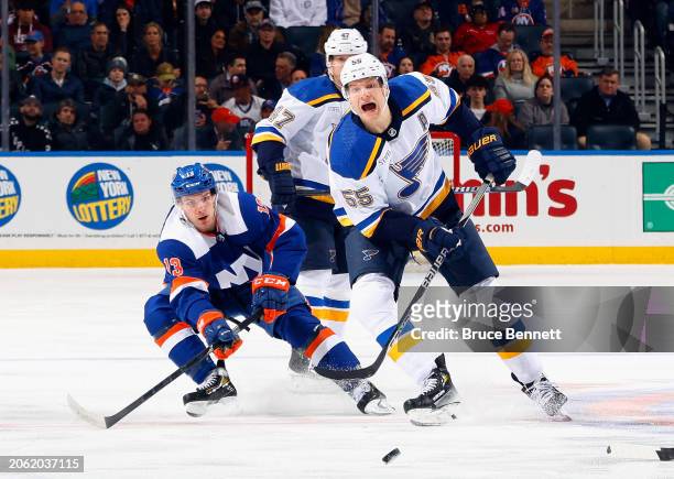 Colton Parayko of the St. Louis Blues and Mathew Barzal of the New York Islanders battle for the puck during the third period at UBS Arena on March...