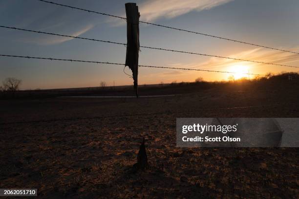 Fence post is suspended by barbed wire after it was burned away in the Smokehouse Creek fire on March 05, 2024 near Canadian, Texas. The fire has...