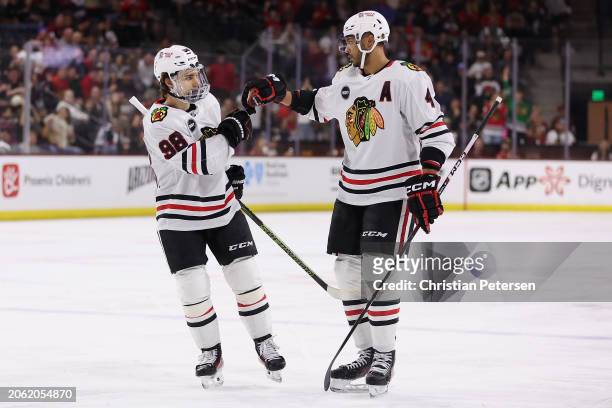 Seth Jones of the Chicago Blackhawks celebrates with Connor Bedard after scoring a a power-play goal against the Arizona Coyotes during the first...