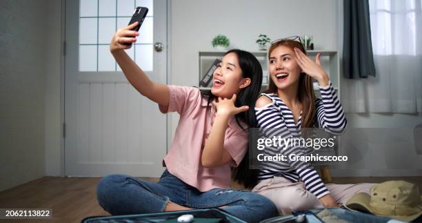 cheerful asian teenager women taking selfie at home and preparing for journey - teen packing suitcase stock pictures, royalty-free photos & images