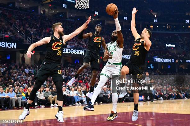 Dean Wade, Caris LeVert and Georges Niang of the Cleveland Cavaliers guard Jaylen Brown of the Boston Celtics during the second quarter at Rocket...