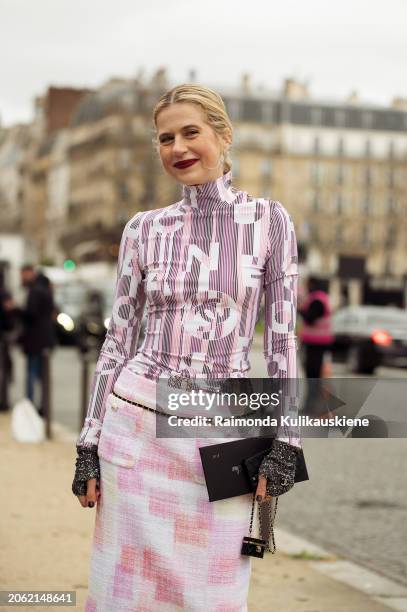 Guest wears pink white and black pattern turtle neck top, matching leggings, pink and white skirt, and black micro bag outside Chanel during the...