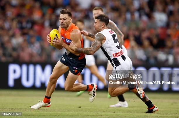 Stephen Coniglio of the Giants is tackled by Jamie Elliott of the Magpies during the 2024 AFL Opening Round match between the GWS GIANTS and the...