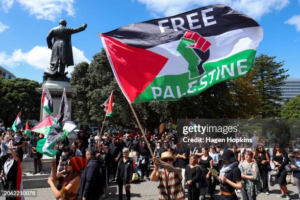 Protestors wave flags during a pro-Palestinian protest at Parliament on March 06, 2024 in Wellington, New Zealand. Fighting in Gaza continues months...