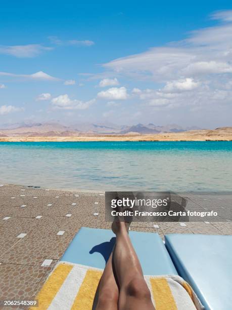young white male putting his feet up in sun in the pool sun lounger - sinai egypt stock pictures, royalty-free photos & images