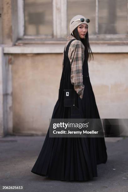 Yoyo Cao seen wearing a Sacai X Carhartt denim long jumpsuit dress, grey hat, Celine black sunglasses and a brown checkered blouse outside Sacai show...