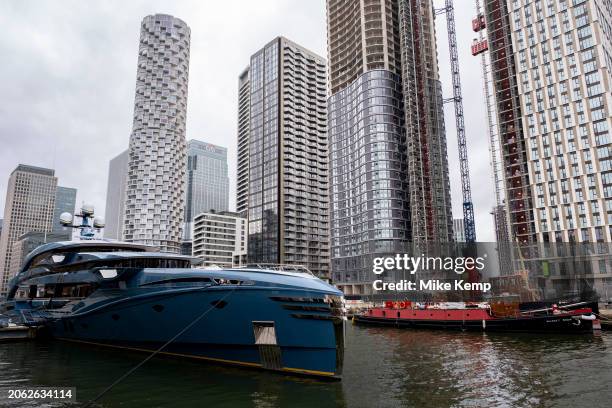 Phi superyacht made by Royal Huisman which is moored at the heart of Canary Wharf financial district alongside new build construction of high rise...