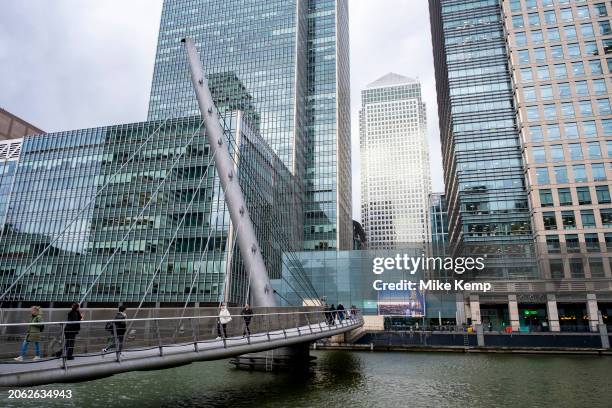 Commuters walk across the South Quay footbridge over the South Dock at the heart of Canary Wharf financial district on 6th February 2024 in London,...