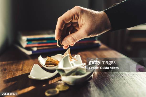 hand counting coins from broken piggy bank. - bankruptcy stock pictures, royalty-free photos & images