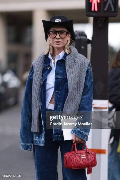 Karin Teigl seen wearing Miu Miu black denim logo cowboy hat, black aviator glasses, Miu Miu light blue striped buttoned shirt, Miu Miu grey cable...