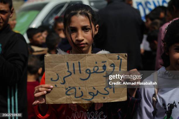 Palestinian children carry banners during a march demanding an end to the war and an end to the famine that citizens suffer from due to the war on...