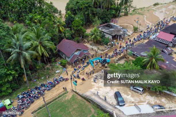 An aerial view shows motorists driving through a muddy road following flash flooding in Pesisir Selatan Regency, West Sumatra on March 9 after days...