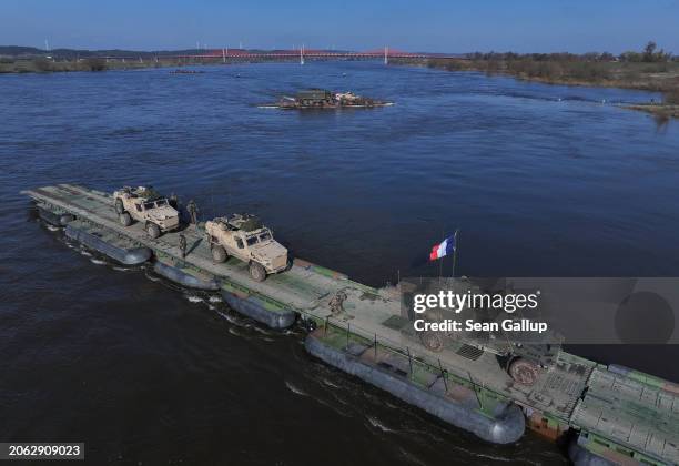 In this aerial view British troops in in Foxhound combat vehicles ride a French military ferry while crossing the Vistula River during the NATO...