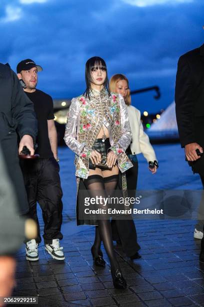 Lisa / Lalisa Manobal wears a floral print colored long jacket , black leather mini shorts, black tights, black leather pointed shoes outside Louis...