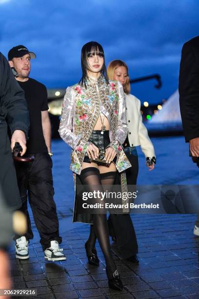 Lisa / Lalisa Manobal wears a floral print colored long jacket , black leather mini shorts, black tights, black leather pointed shoes outside Louis...