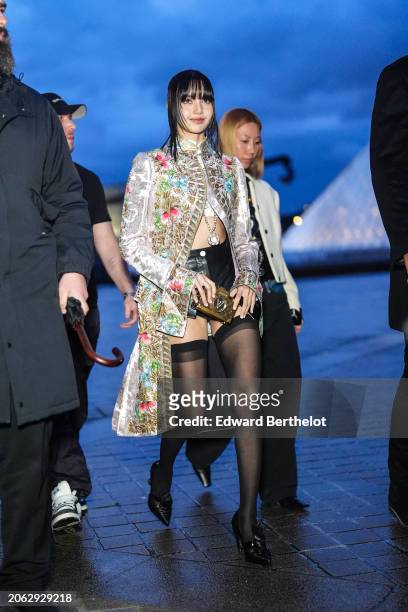 Lisa / Lalisa Manobal wears a floral print colored long jacket , black leather mini shorts, black tights, black leather pointed shoes outside Louis...