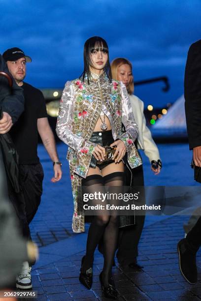 Lisa / Lalisa Manobal wears a floral print colored long jacket , black leather mini shorts, black tights, black leather pointed shoes outside Louis...