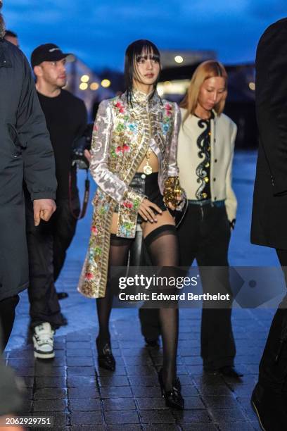 Lisa / Lalisa Manobal wears a floral print colored long jacket , black leather mini shorts, black tights, black leather pointed shoes outside Louis...