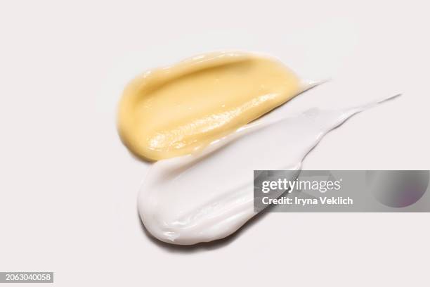 waved texture of cosmetic products - skincare face cream, refreshing hydration water cream, face gel, hand cream on white color background. - haarbehandeling stockfoto's en -beelden