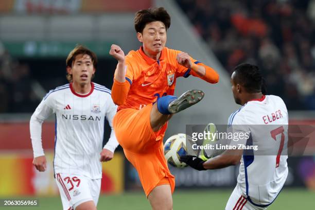 Gao Zhunyi of Shandong Taishan competes for the ball against Elber of Yokohama F.Marinos during the first half of the AFC Champions League quarter...