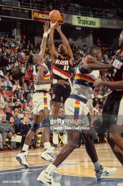 Buck Williams, Power Forward for the Portland Trail Blazers makes a jump shot over the attempted block by Dikembe Mutombo, Center for the Denver...