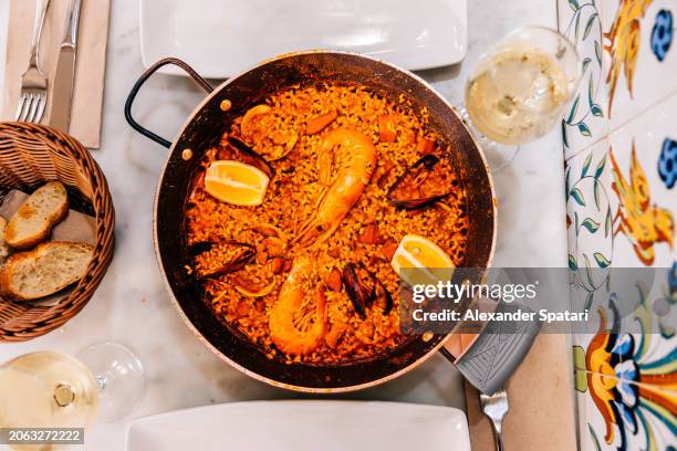 paella with seafood served at the restaurant, directly above view - comfort food fotografías e imágenes de stock