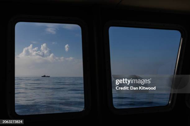 An inflatable dinghy carrying migrants is escorted by a French search and rescue vessel across the English Channel towards British Waters on March...