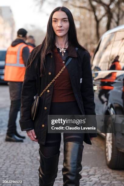 Mariacarla Boscono wears brown top, black leggings, black jacket, black over the knees boots, outside Sacai, during the Womenswear Fall/Winter...