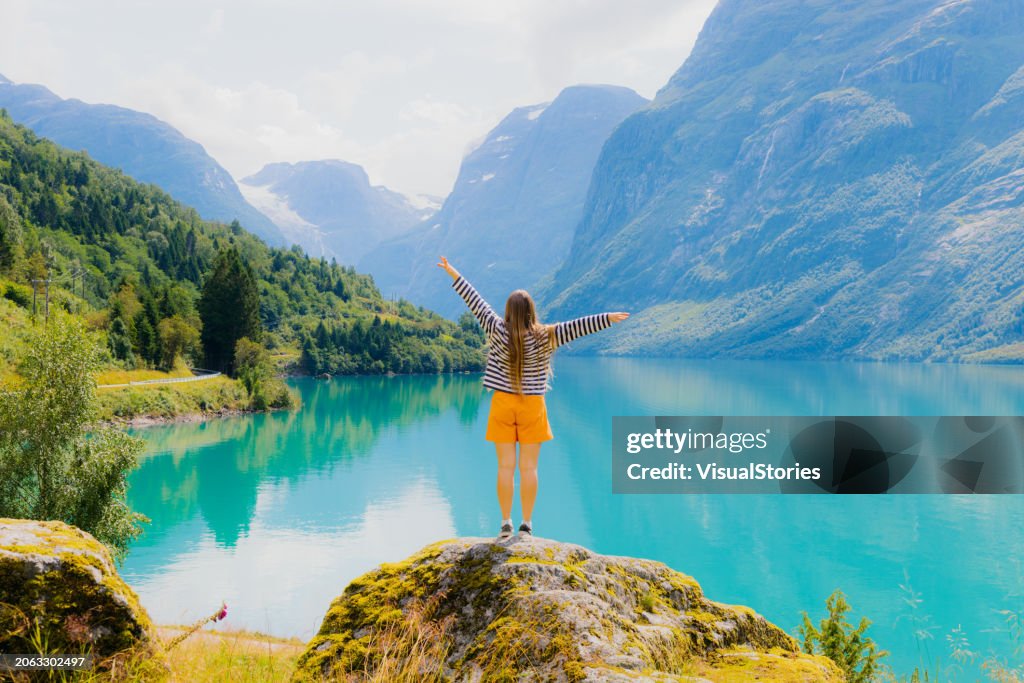 Woman Tourist Admiring Summer with Scenic View of Lake Lovatnet in Norway
