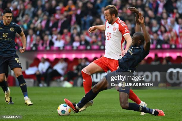 Bayern Munich's English forward Harry Kane and Mainz's French midfielder Josuha Guilavogui vie for the ball during the German first division...