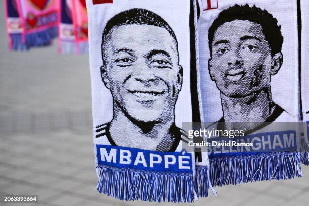 Scarves of Kylian Mbappe and Jude Bellingham hang in a souvenir stall outside the stadium prior to the UEFA Champions League 2023/24 round of 16...