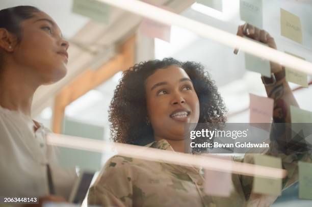 des hommes d’affaires, des femmes et l’écriture sur des post-it pour le brainstorming, la planification et la carte mentale de notre vision sur la vitre. travail d’équipe, employé et informations pour la stratégie, l’ordre du jour et la relance - tableau transparent photos et images de collection