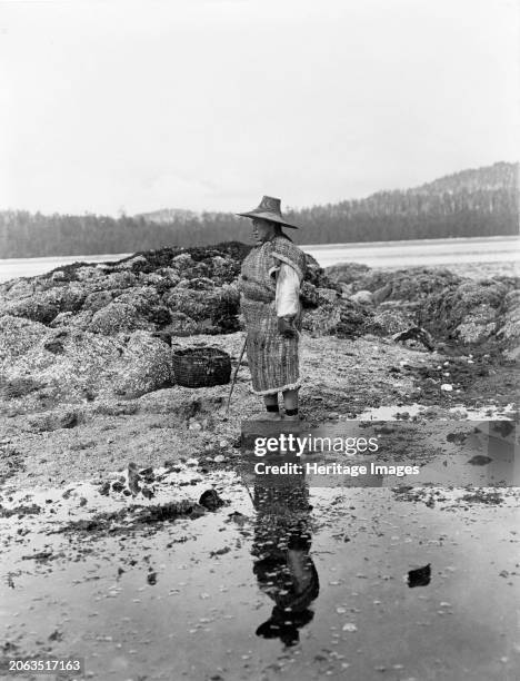 Hazy morning-Nakoaktok, circa 1910. Nakoaktok man standing on shore. Creator: Edward Sheriff Curtis.