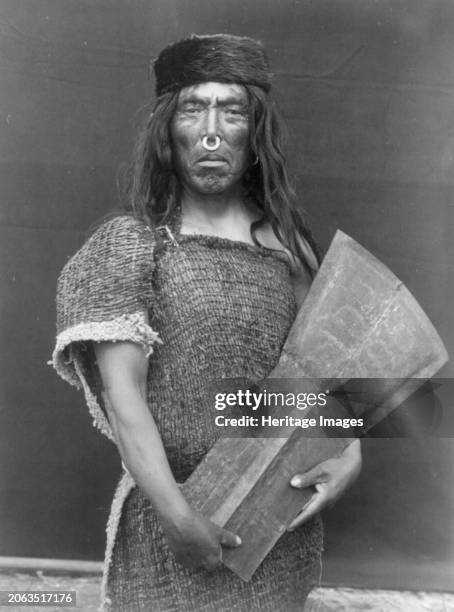 Nakoaktok chief and copper, circa 1914. Hakalahl, Nakoaktok chief, three-quarter length portrait, standing, facing front, holding copper Wanistakila...