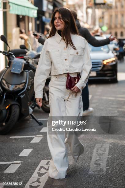 Belen Hostalet wears white crop denim jacket, matching jeans, burgundy Gucci bag, outside Zimmermann, during the Womenswear Fall/Winter 2024/2025 as...