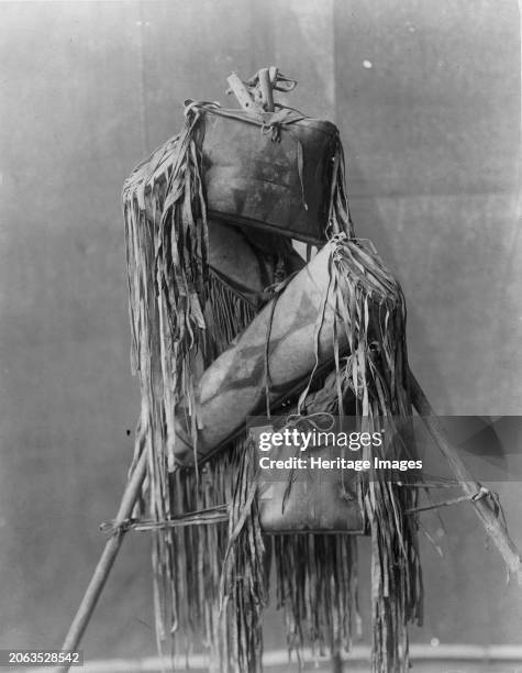 Medicine bags, circa 1910. Four Piegan fringed leather containers hung on tripod. Creator: Edward Sheriff Curtis.