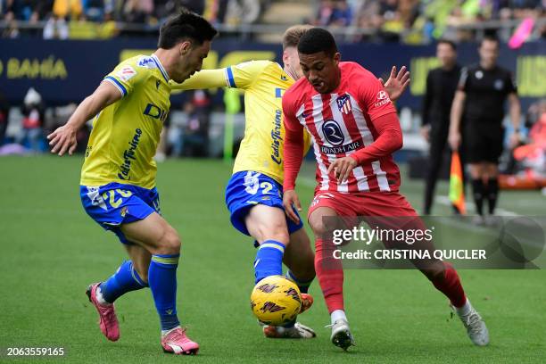 Atletico Madrid's Brazilian forward Samuel Lino fights for the ball with Cadiz's Spanish forward Roger Marti and Cadiz's Spanish defender Isaac...