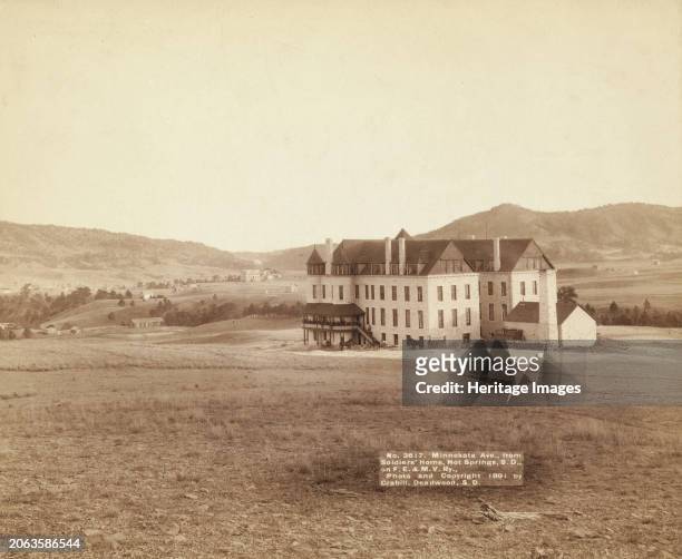 Minnekata Ave, from Soldiers' Home, Hot Springs, SD, on FE and MV Ry, 1891. Large building in open field with small buildings and mountains in...