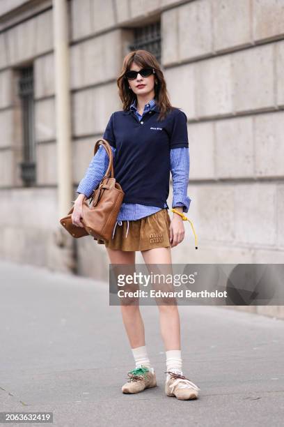 Guest wears sunglasses,a navy blue polo shirt, a blue shirt with printed checkered / checked pattern, a large brown leather bag, a Miu Miu gathered...