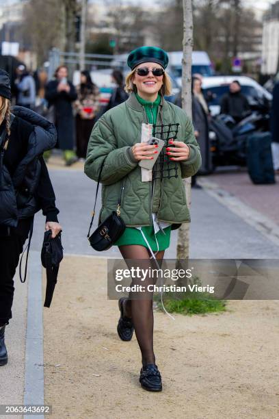 Guest wears beret, green quilted jacket, skirt, zipper, tights outside Lacoste during the Womenswear Fall/Winter 2024/2025 as part of Paris Fashion...