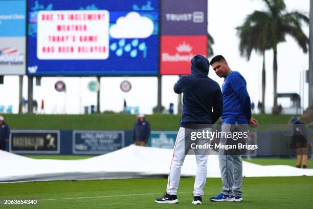 Manager Jose Espada of the Houston Astros and Manager Carlos Mendoza of the New York Mets evaluate the field during a rain delay prior to a spring...