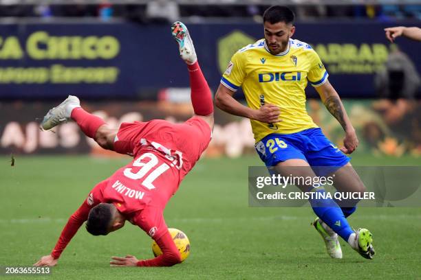 Atletico Madrid's Argentine defender Nahuel Molina falls down as he fights for the ball with Cadiz's Uruguayan forward Maximiliano Gomez during the...