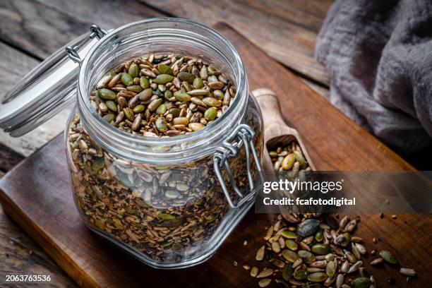 roasted sunflower and pumpkin seeds mixture in a glass container - sesam stockfoto's en -beelden
