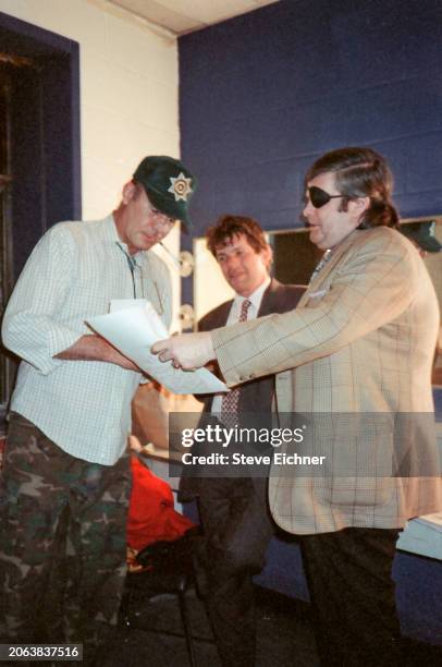 As American magazine publisher & Rolling Stone co-founder Jann Wenner watches, journalist & author Hunter S Thompson signs an autograph during an...